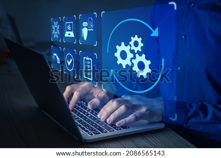 Robotic Process Automation (RPA) technology to automate business tasks with AI. Concept with expert setting up automated software on laptop computer. Digital transformation and change management. Royalty-Free Stock Photo #2086565143