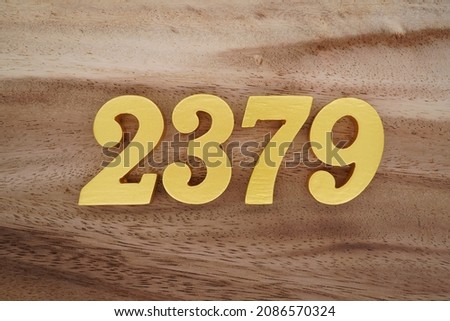 Golden Arabic numerals 2379 on a dark brown to white wood grain background.