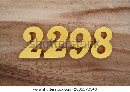 Golden Arabic numerals 2298 on a dark brown to white wood grain background.