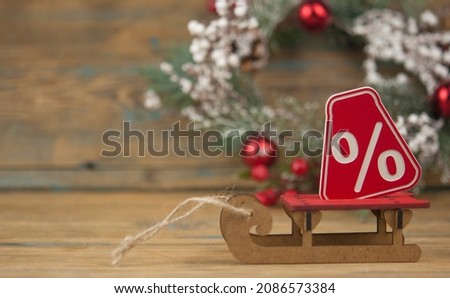 sledge with a big percent sign on wood background with copy space. Christmas big sale