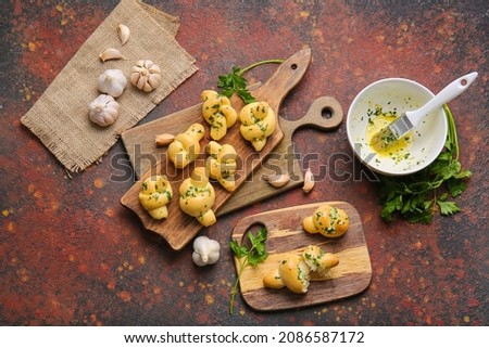 Boards with tasty garlic buns on grunge background