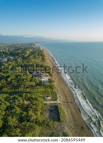 Drone view of the sea, beach, apartment on the seashore on a sunny evening, wild beach. Vertical photo