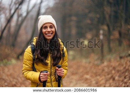 Picture of a relaxed adult woman, smiling for the camera, during hike.