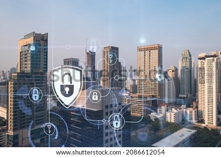 Hologram of Padlock on sunset panoramic cityscape of Bangkok, Southeast Asia. The concept of cyber security intelligence. Multi exposure.