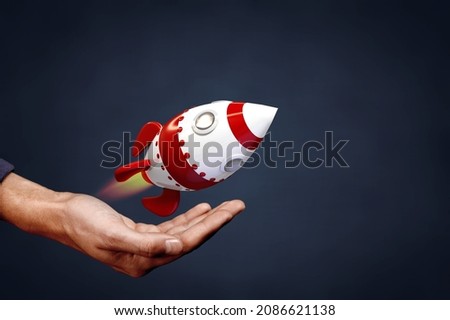 Bitcoin cryptocurrency rocket growth concept. Model of rocket representing fast growth and hand.