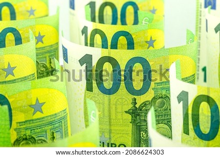 Macro photo of the European Union 100 EURO banknote, banknotes rolled up and standing, isolated on a white background, selective focus.