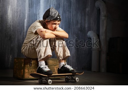 sad teenager sitting on skateboard