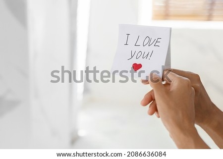 Unrecognizable Woman Putting Sticky Note With I Love You Text On Mirror, Closeup Shot Of Female Hand Sticking Paper, Leaving Handwritten Romantic Messase With Drawn Heart, Cropped Image