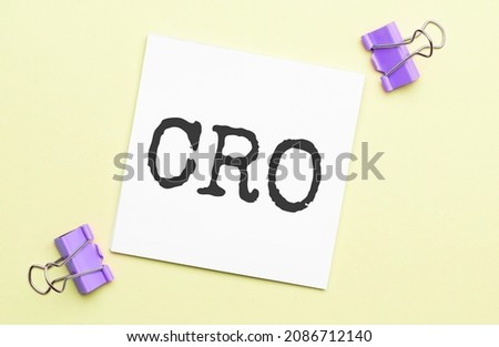 white paper with text cro on a yellow background with stationery
