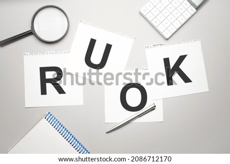 magnifier,calculator, pen and paper sheet with text RUOK