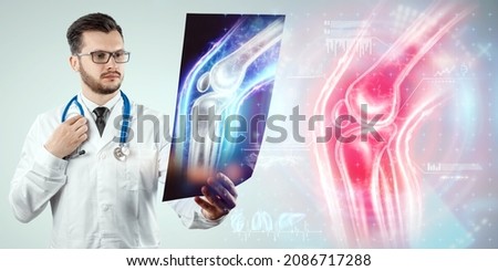 The doctor looks at the X-ray of the sore knee, severe pain. X-ray image, trauma, rheumatologist consultation, skeletal image, medical concept, medical technologies of the future, pain when walking Royalty-Free Stock Photo #2086717288