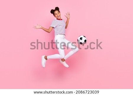 Full body photo of childhood brown haired african american trendy girl wear casual outfit jump ball kick isolated on pink color background