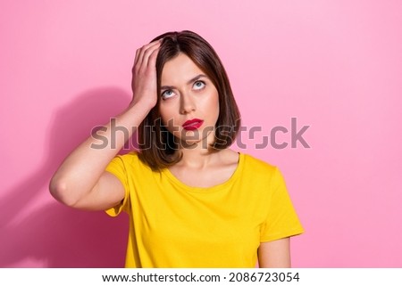 Photo of brunette sad young lady look up wear vivid t-shirt isolated on pastel pink color background