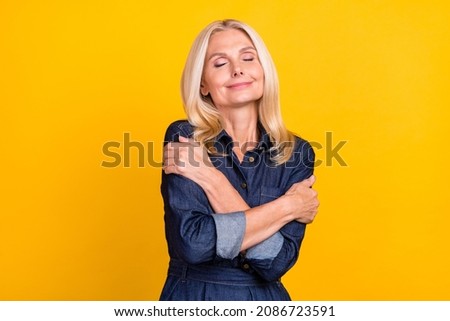 Photo of pretty dreamy woman wear jeans clothes embracing herself closed eyes isolated yellow color background Royalty-Free Stock Photo #2086723591