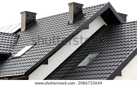 Roof of a new home. Ceramic chimney, metal roof tiles, gutters, roof window. TV antennas attached to the chimney. Single family house. Royalty-Free Stock Photo #2086733644