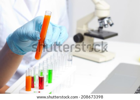 Hand in glove holding test tube