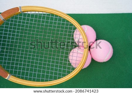Tennis balls and racket on tennis court.                        