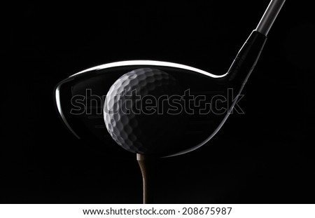 Teeing off/Golf ball club and tee on black background