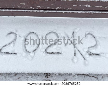 New 2022 year coming soon. Numbers written on the snow by a finger. 2022 soon