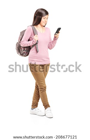 Full length portrait of a schoolgirl looking at her cell phone isolated on white background