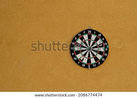 New Colorful Dart board isolated on yellow cork board background