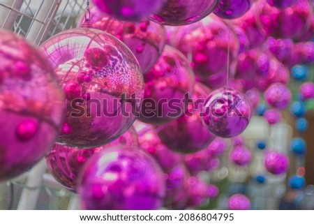 Hanging pink ornaments ball with colorful blur background in a decorative tunnel