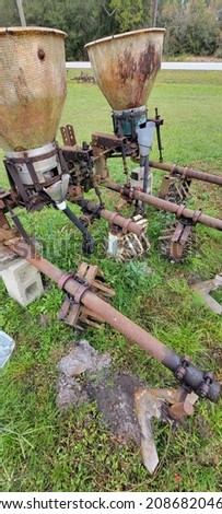 Various automated pull behind vintage antique farm and garden tiller showing signs of age with rusting found in North Florida countryside 