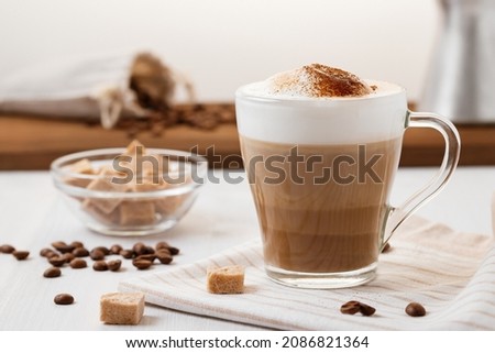 Latte coffee poured in layers with froth and a crispy chocolate top on a light kitchen table Royalty-Free Stock Photo #2086821364