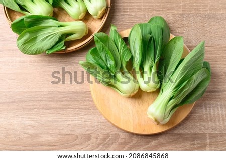 Fresh Bok Choy or Pak Choi (Chinese cabbage) on cutting wooden board, Table top view Royalty-Free Stock Photo #2086845868