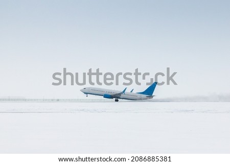 Takeoff of a passenger jet plane in a severe snowstorm Royalty-Free Stock Photo #2086885381