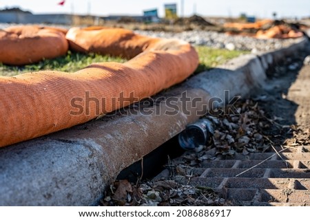Filter sock placed to prevent erosion runoff of soil into an open storm drain Royalty-Free Stock Photo #2086886917