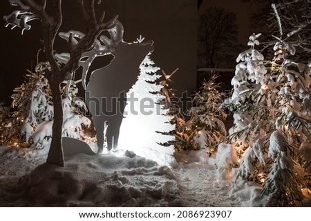 White illuminated animals and trees cut from veneer - Christmas decor at night, Kuldiga, Latvia.