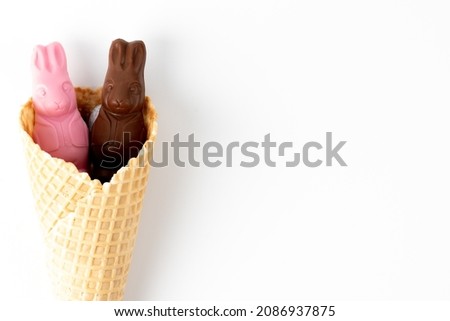 Chocolate bunnies in a waffle cone on white background with blank space for text. Delicious Easter holiday chocolate bunny sweets
