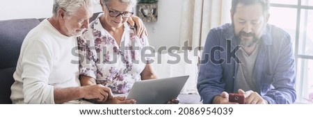Horizontal banner header with adult and senior family together using modern devices as mobile phone and laptop computer. Concept of password security and modern people enjoying technology online