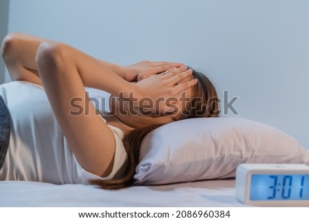 Annoyed, Stressed, asian young beautiful, pretty woman, girl suffering from insomnia, awake in bed at night, covering face with hand because of disturbed loud noise, unable sleep. Restless people. Royalty-Free Stock Photo #2086960384