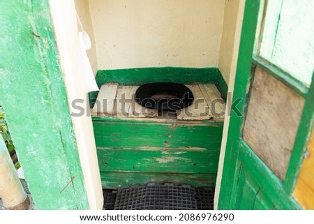 Rural toilet. A public or private toilet outside the home, on a farm, or along a road. An old toilet with a cesspool. Inside view. Russian toilet. 