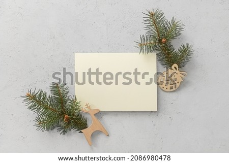 Composition with blank card, fir branches and Christmas decorations on light background