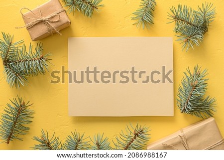 Composition with blank card, fir branches and Christmas gifts on color background