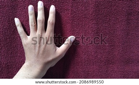 Adult male finger on red towel background