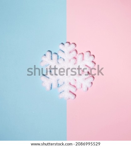 Snowflake Christmas decoration against pastel pink blue background. Minimal winter holidays layout. 