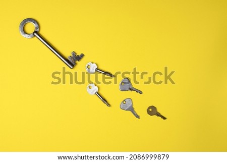 Door keys of different shapes on a bright yellow background. Trendy flat lay concept.