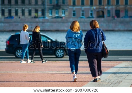 a woman and her adult daughter are walking down the street. back view. High quality photo