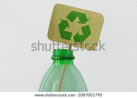 Plastic bottle with recycling symbol on recycled paper sign - Ecology concept