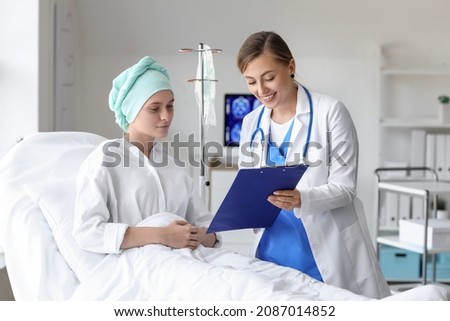Doctor telling good news to woman after chemotherapy in clinic Royalty-Free Stock Photo #2087014852