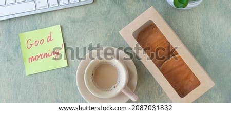 banner with flat lay with of the desktop. note with the words GOOD MORNING, pancakes in paper box, cup of coffee, keyboard, cactus and mause on a wooden table. concept of good start to day. top view
