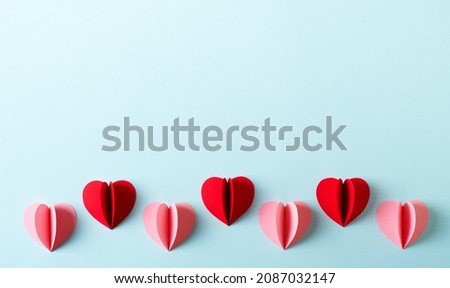 Red and pink paper hearts valentine or mothers day concept flat lay on blue background, copy space, top view