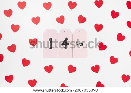 Romantic backround with text 14 Feb and red paper confetti hearts on white. Valentines Day celebration concept, holiday flat lay