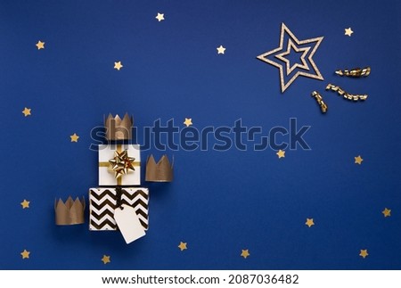 Traditional Three King's Day of January 6. Three gold crowns on blue background. Concept for Dia de Reyes Magos day, three Wise Men. Happy Epiphany day. Top view, copy space, flat lay.