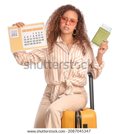Sad woman with calendar, suitcase, ticket and passport on white background. Vacation concept