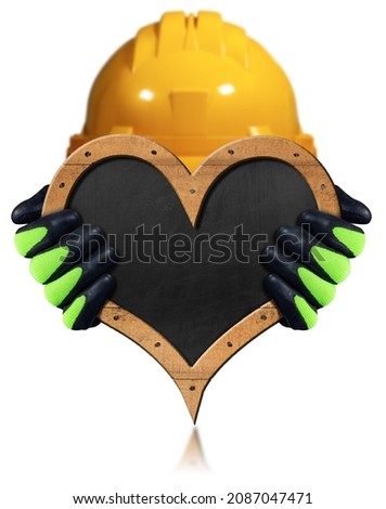 Manual worker with protective work gloves and hard hat, holding a blank blackboard in the shape of a heart with copy space, isolated on white background.